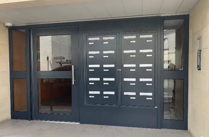 installation d'une porte de hall avec l'intégration des boîtes aux lettres directement dans la menuiserie de la porte 