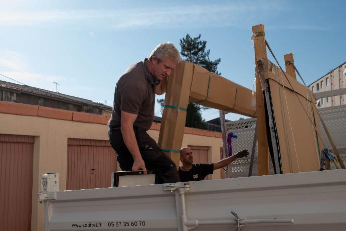 photo d'un technicien en porte qui soulève une porte de hall